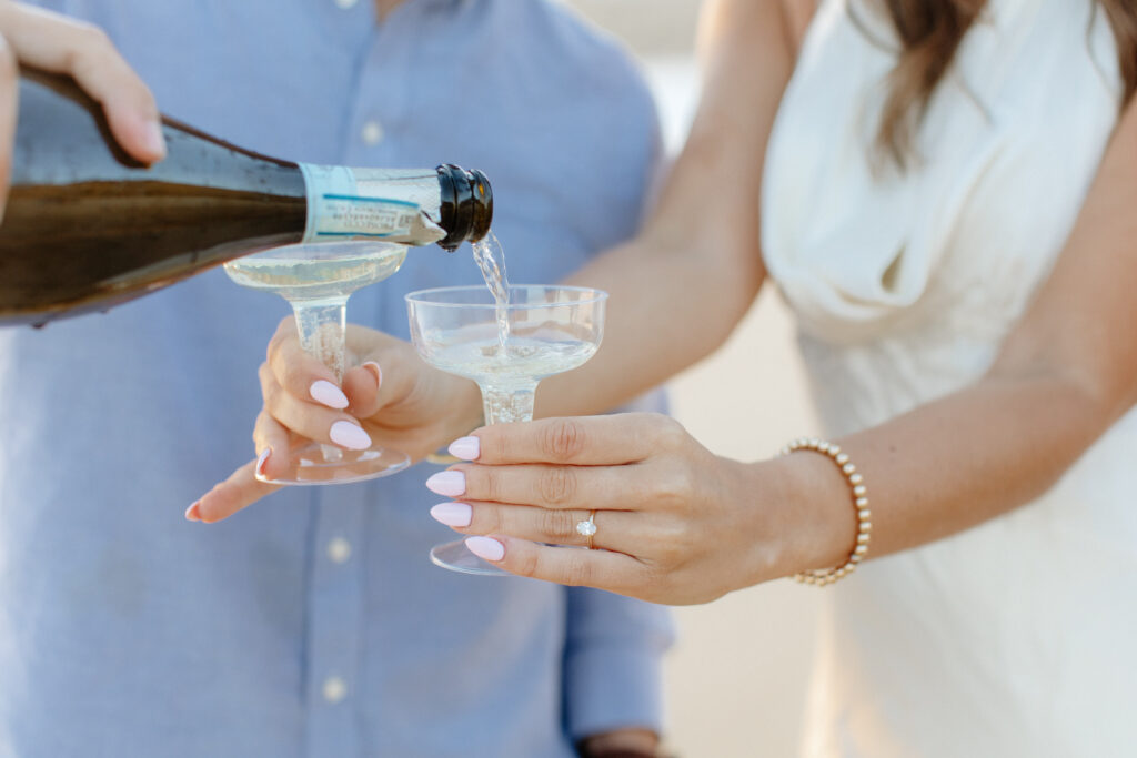 newly engaged with champagne and wedding ring 