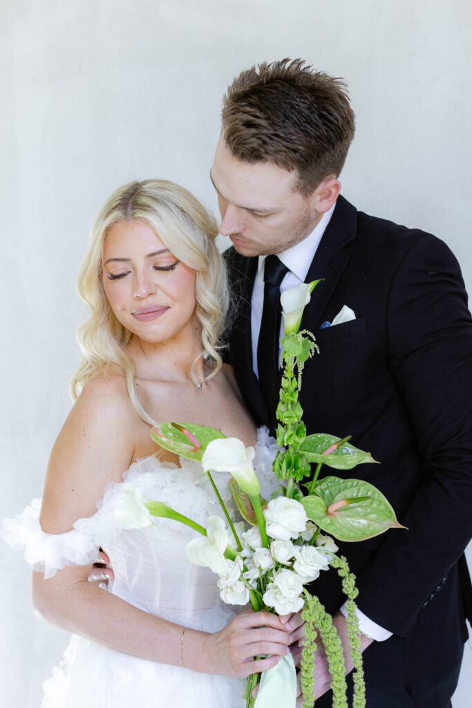 Bride and groom in white chapel with greenery and hydrangeas