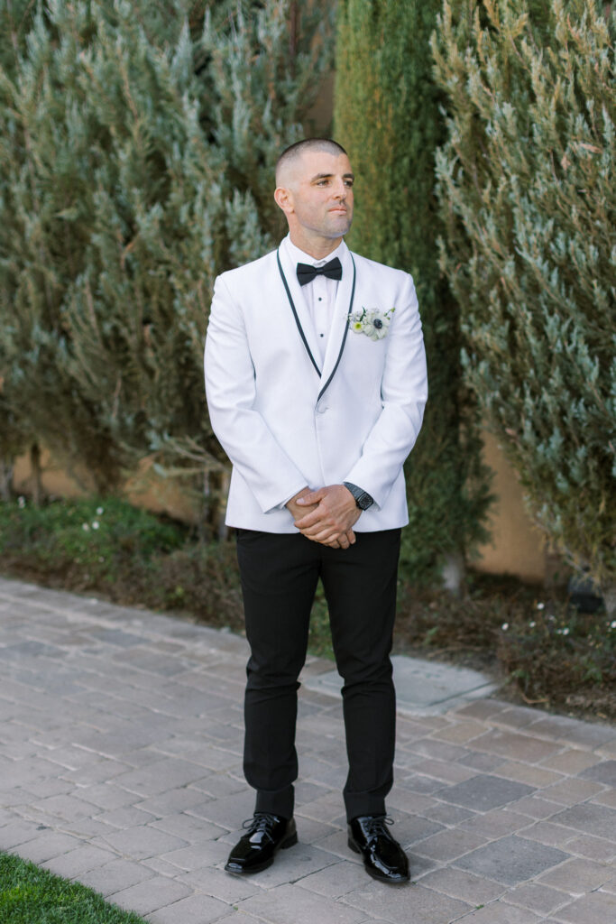 Groom in white tux at the palm event center in livermore ca