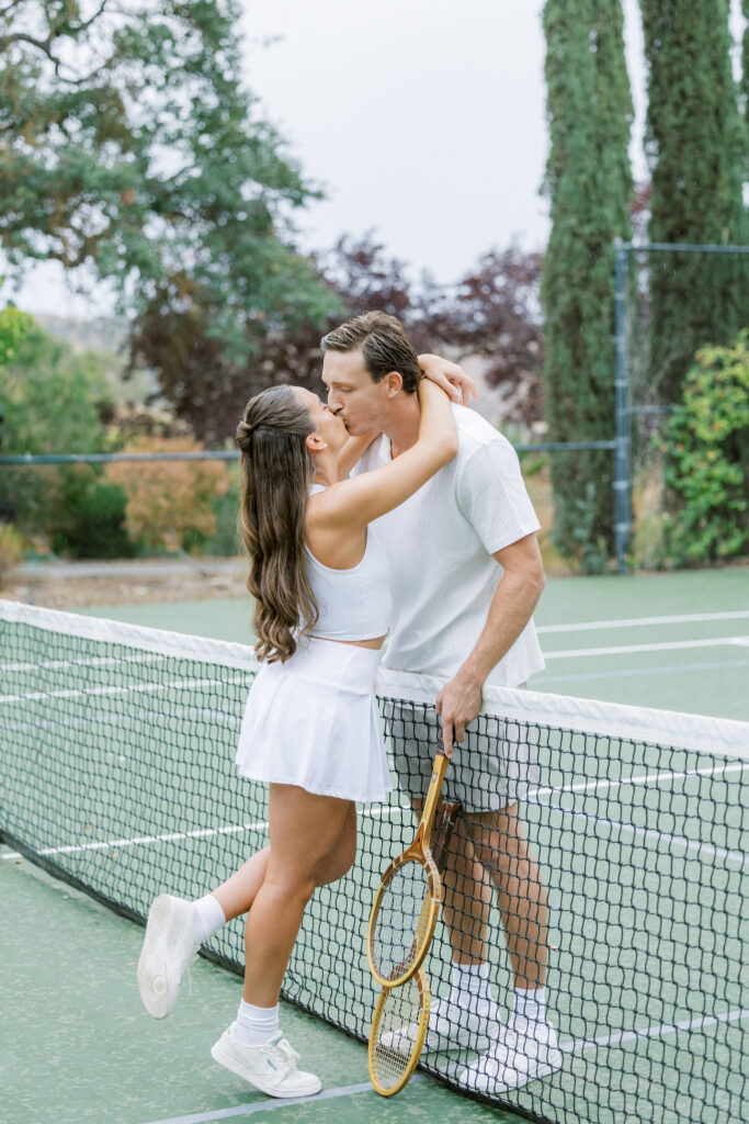 Couple kissing on tennis court during romantic Paso Robles engagement session at Eagle Oak Ranch