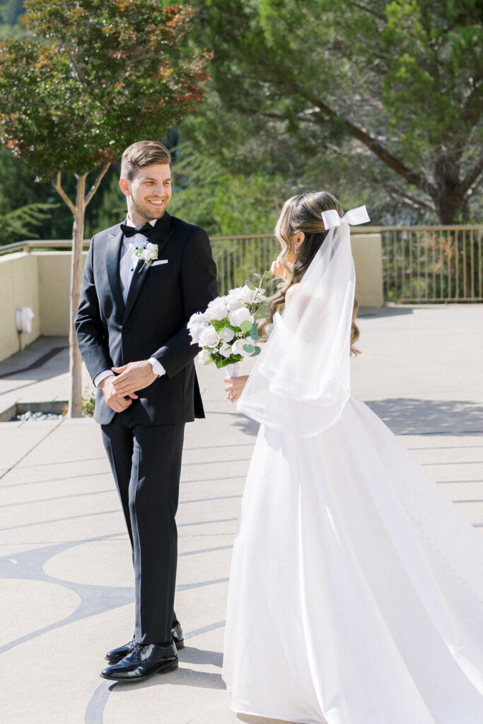 Bride and groom sharing a joyful moment in front of the chapel at University Redlands Marin