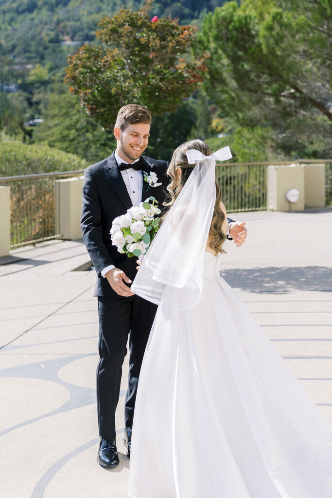 Bride and groom sharing a joyful moment in front of the chapel at University Redlands Marin