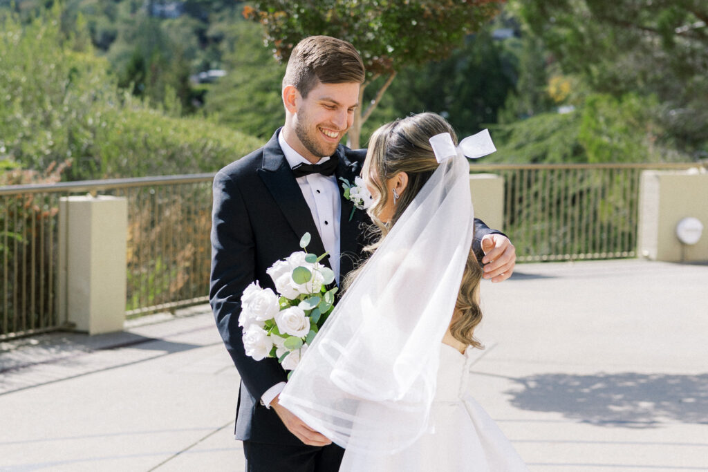 Bride and groom sharing a joyful moment in front of the chapel at University Redlands Marin