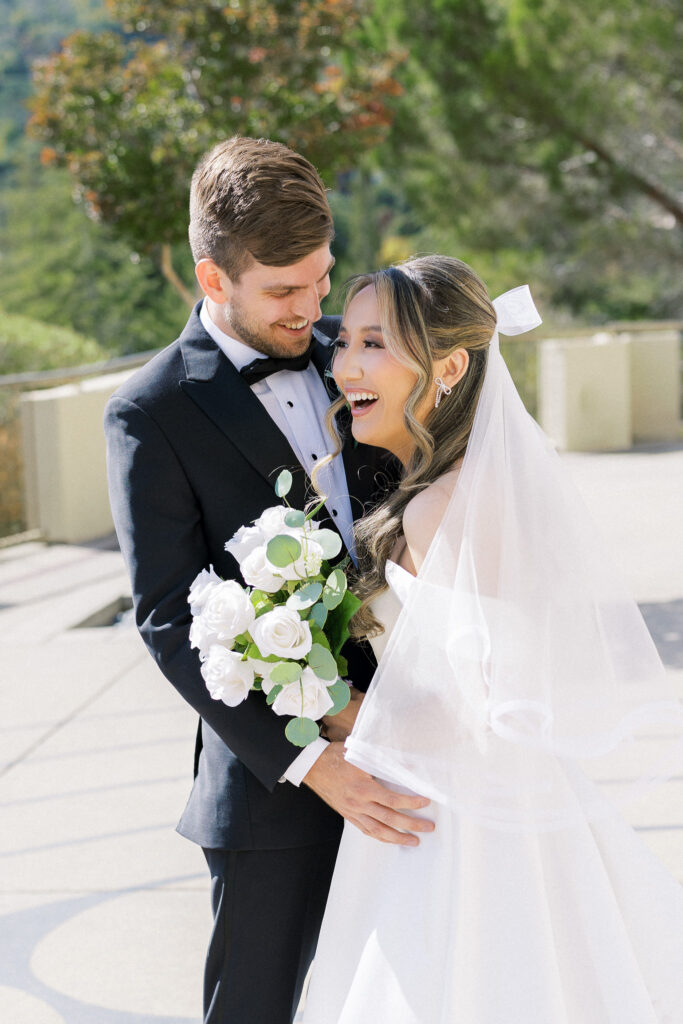 Bride and groom sharing a joyful moment in front of the chapel at University Redlands Marin