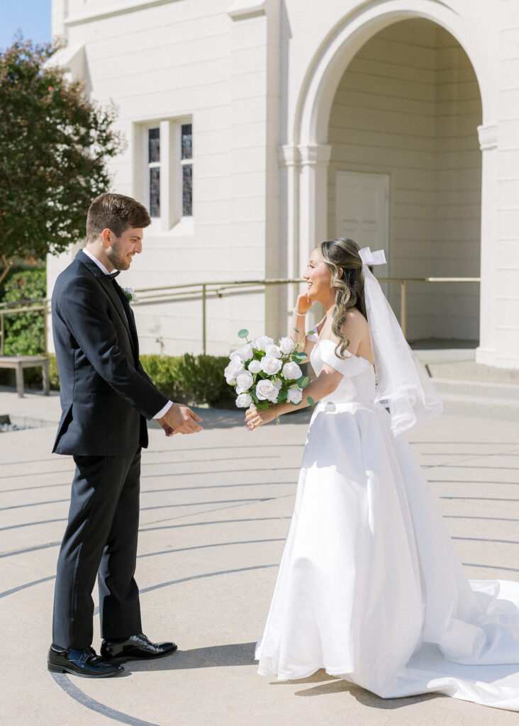 Bride and groom sharing a joyful moment in front of the chapel at University Redlands Marin