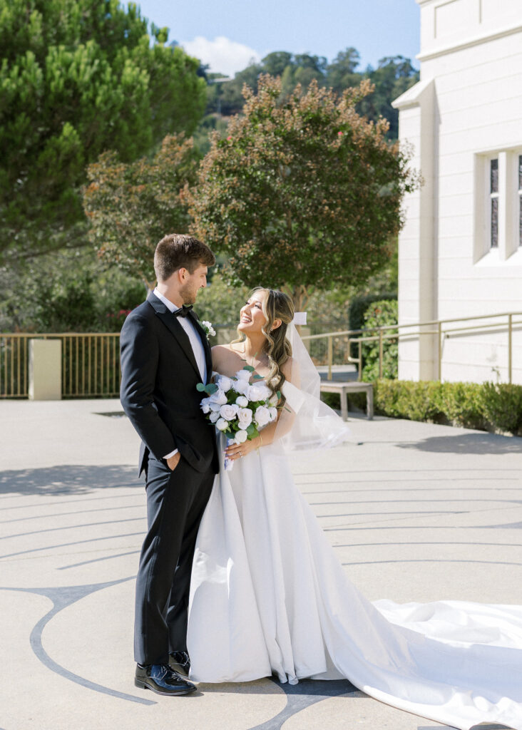 Bride and groom sharing a joyful moment in front of the chapel at University Redlands Marin