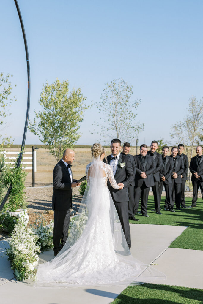 Outdoor ceremony setup at The Margaux wedding venue with modern circular arch and white floral aisle décor.