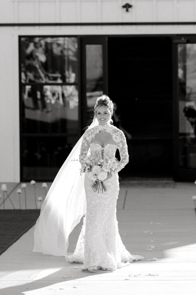 Outdoor ceremony setup at The Margaux wedding venue with modern circular arch and white floral aisle décor.