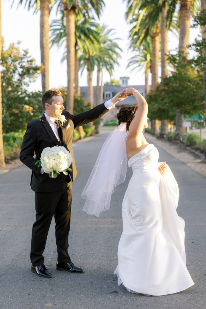 Couple walking hand in hand along palm tree lined driveway at The Palm Event Center