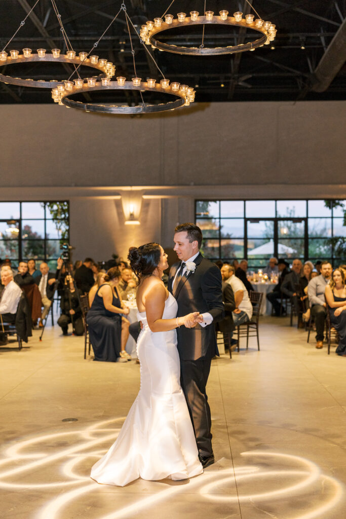 Elegant candle chandelier over monogram dance floor at The Palm Livermore wedding