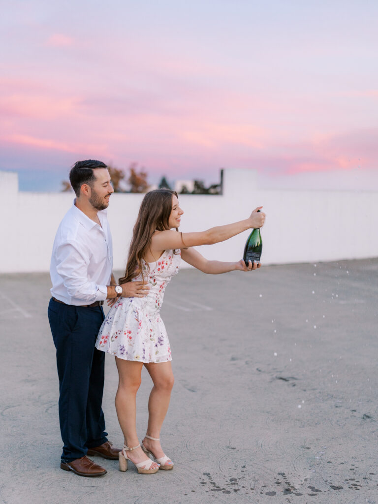 Couple sharing a sunset kiss on a Sacramento parking garage rooftop with city views