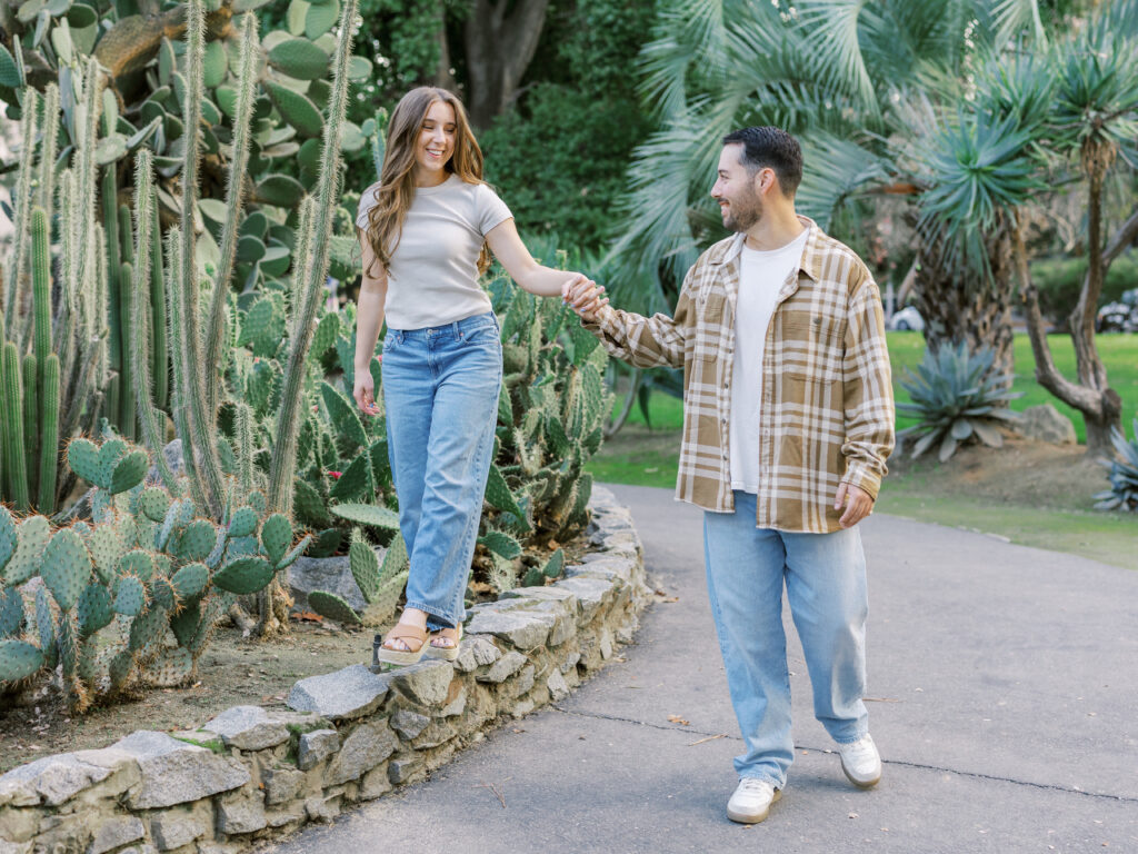 Couple walking hand in hand through the Capitol Rose Garden during their Sacramento engagement session