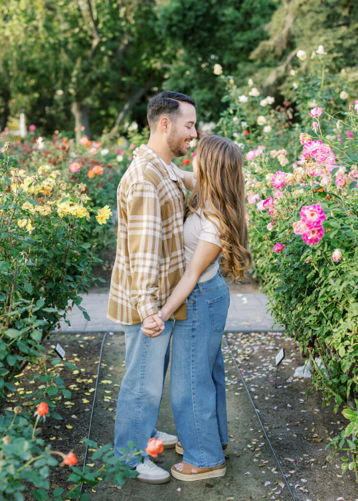 Couple walking hand in hand through the Capitol Rose Garden during their Sacramento engagement session