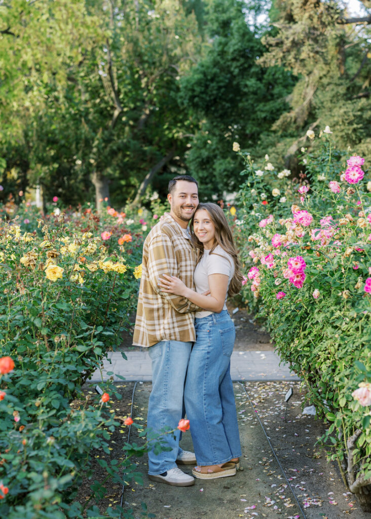 Couple walking hand in hand through the Capitol Rose Garden during their Sacramento engagement session