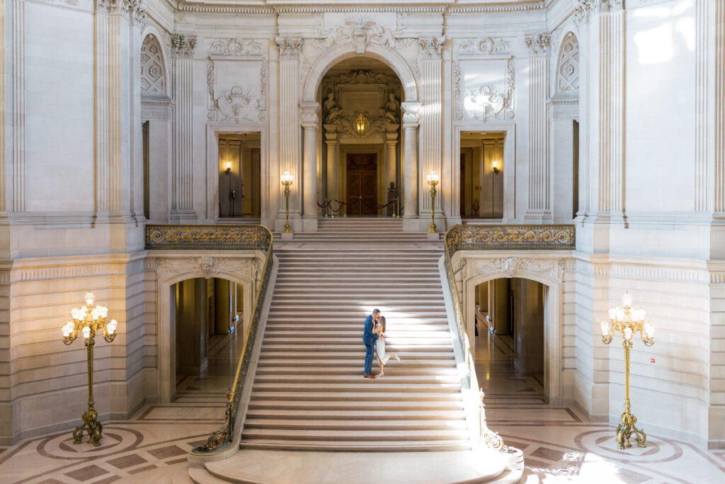 Couple walking up the grand staircase at San Francisco City Hall during engagement session |San Francisco City Hall Engagement Photos