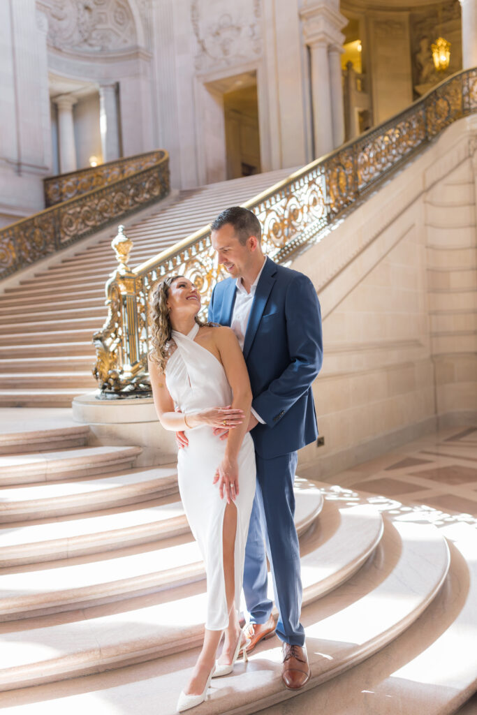 Elegant engagement portrait of couple in front of marble interior at SF City Hall
