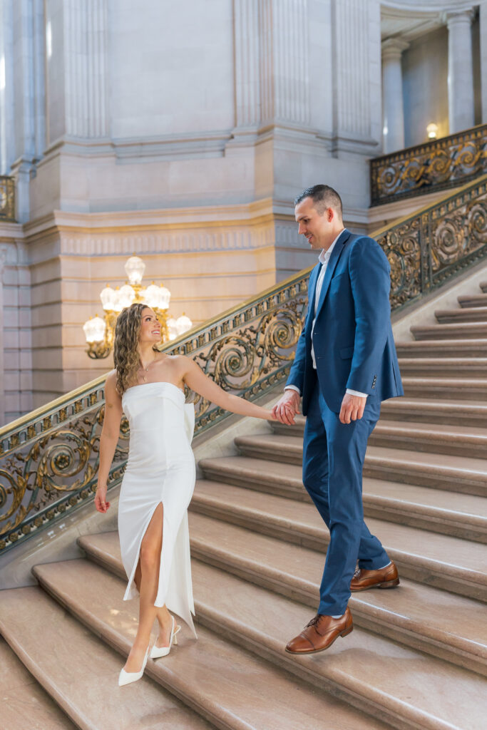 Elegant engagement portrait of couple in front of marble interior at SF City Hall