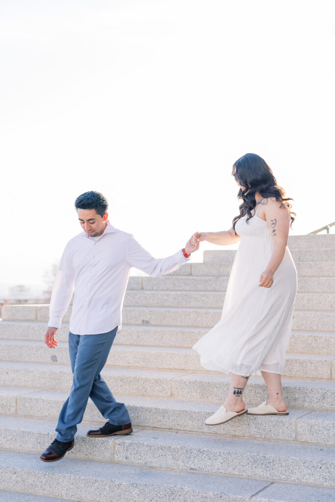 Utah Capitol engagement session couple walking on steps at sunset